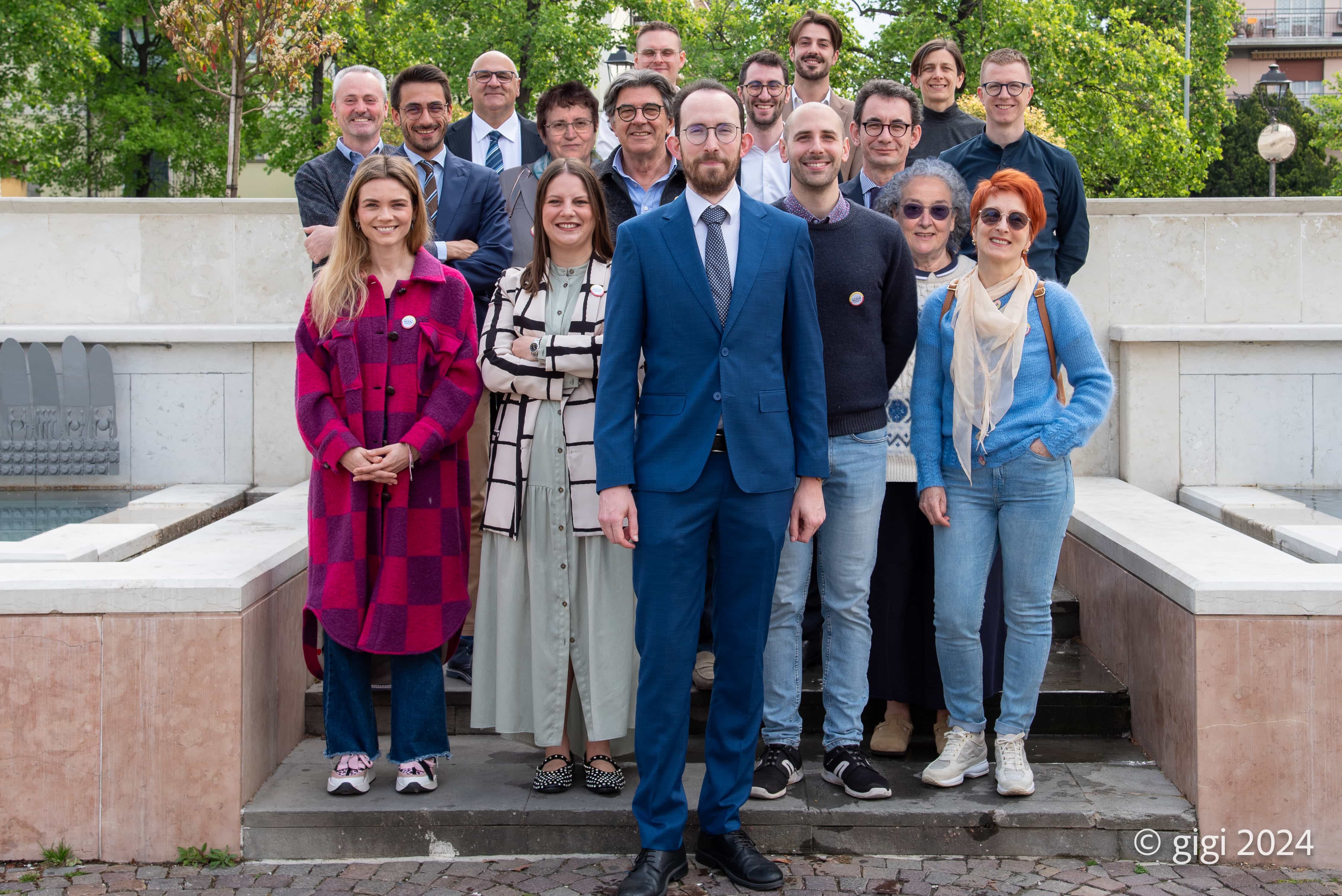 Foto di gruppo dei componenti della lista del comitato civico Marco Salogni. La foto è stata scattata su una gradinata all'aperto con i candidati cosiglieri in piedi dietro al candidato sindaco Marco Salogni