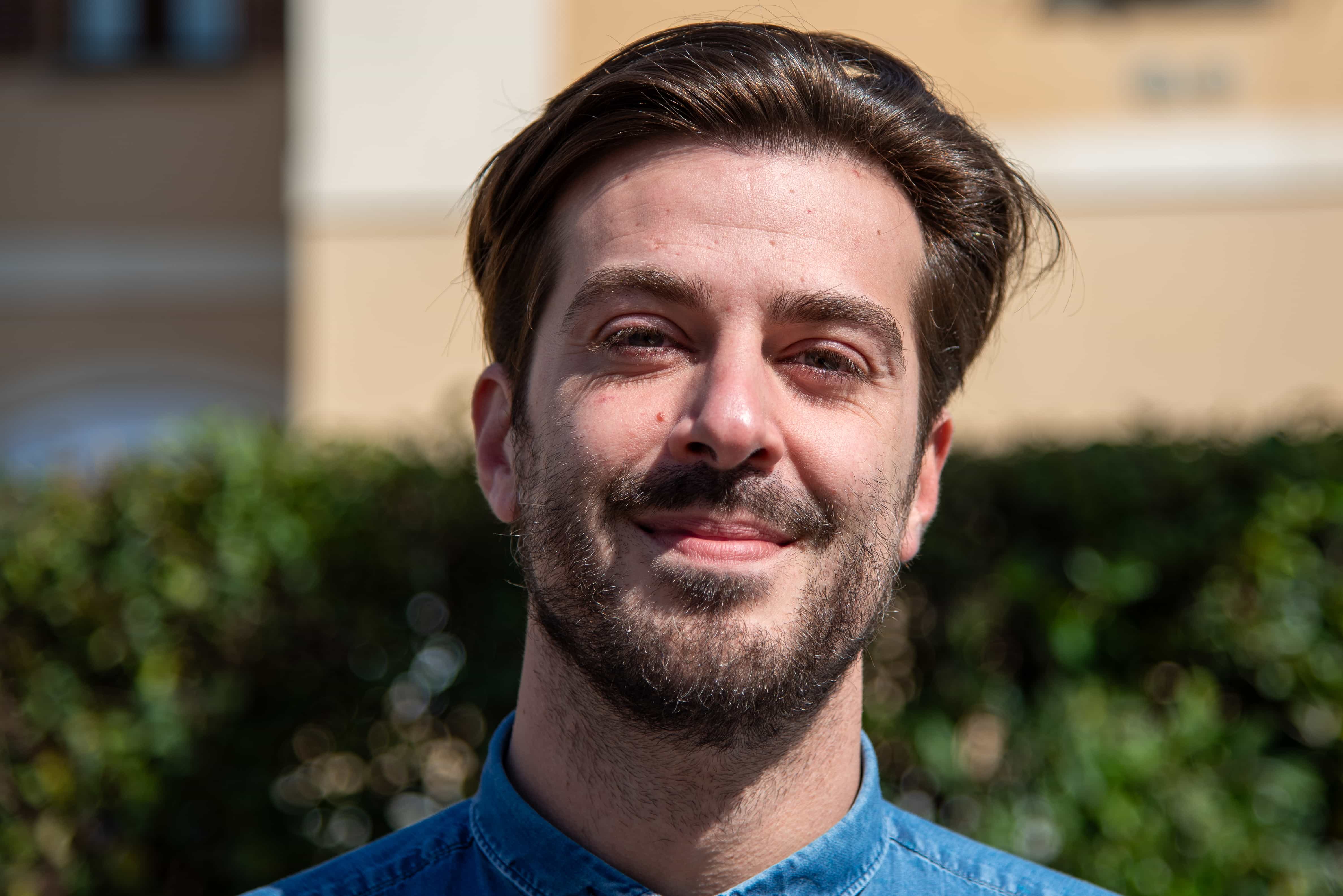 Giacomo Loschi in primo piano in camicia che guarda sorridente l'obiettivo